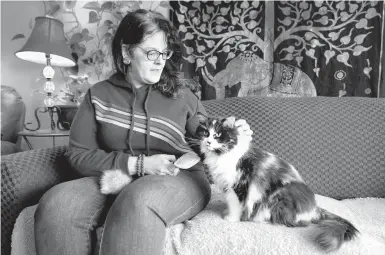  ?? CHARLIE NEIBERGALL/AP ?? For Tara Kramer, shown with her cat Busy, her monthly SNAP benefit plunged from $250 in March to just $20 in April.