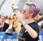  ?? KATHY WILLENS/ASSOCIATED PRESS ?? United States women’s soccer team member Megan Rapinoe waves as she holds the Women’s World Cup trophy on Monday.