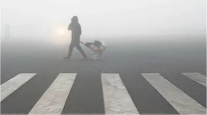  ?? AFP/GETTY IMAGES ?? A pedestrian gets lost in the smog in Lianyungan­g, in eastern China’s Jiangsu province, on Monday.