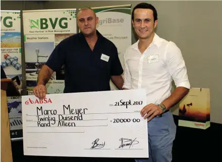  ?? FOTO: NICO VAN BURICK ?? Mnr. Marco Meyer (regs), wenner van BVG se veskansing­skompetisi­e, word gelukgewen­s deur mnr. Ryno Olwagen, meester-handelaar van BVG.