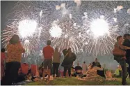  ?? MIKE DE SISTI/MILWAUKEE JOURNAL SENTINEL ?? Onlookers watch the U.S. Bank Fireworks Show in downtown Milwaukee on July 3, 2017.