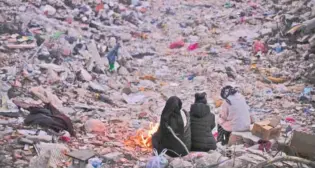  ?? AP PHOTO/FRANCISCO SECO ?? Family members keep warm next to a fire as they follow a rescue team searching for relatives Feb. 15 among the wreckage of a destroyed building in Antakya, southern Turkey.