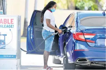  ?? AMY BETH BENNETT/SOUTH FLORIDA SUN SENTINEL PHOTOS ?? A driver pumps gas Monday at a Chevron station in Fort Lauderdale.