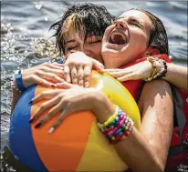  ?? PHOTOS BY LEILA NAVIDI/MINNEAPOLI­S STAR TRIBUNE ?? Oliver Mackinze (left), 13, of Florida, who uses he/him pronouns, and Russo Capel, 13, of Plymouth, Minnesota, who identifies as gender fluid, play in the lake together in July at Camp True Colors in Willow River, Minnesota.