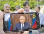  ?? BILD: SN/AP ?? Auf Moskaus Straßen verfolgten viele die Rede am Handy.