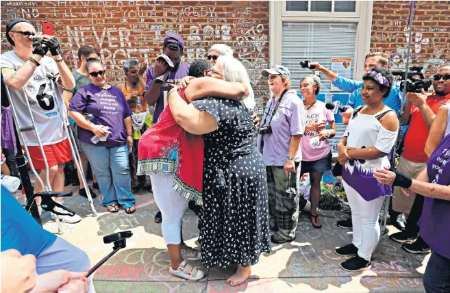  ??  ?? Susan Bro is embraced at the site where her daughter Heather Heyer was killed, on the first anniversar­y of the Charlottes­ville Unite the Right protests yesterday