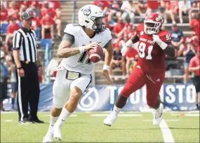  ?? Gary Kazanjian / Associated Press ?? UConn quarterbac­k Jack Zergiotis rolls out against Fresno State on Saturday.