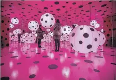  ?? BERNARD WEIL TORONTO STAR ?? A woman stands inside one of the installati­ons in the Infinity Room. The piece is part of of a display of the work of artist Yayoi Kusama, on display at the Art Gallery of Ontario, Toronto.