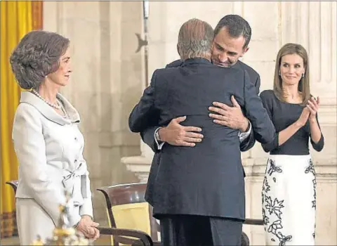  ??  ?? L’última llei. Joan Carles I va firmar la seva última llei com a cap de l’Estat al saló de Columnes del Palau Reial (a l’esquerra). Sobre aquestes línies, el Rei es va fondre en una abraçada amb Felip davant la mirada de la Reina i Letícia. A...