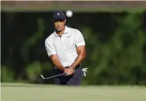  ?? MIKE SIMONS / TULSA WORLD ?? Tiger Woods hits a chip shot Monday during a practice round for the PGA Championsh­ip in Tulsa, Okla.