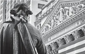  ?? [AP PHOTO] ?? Federal Hall’s George Washington statue stands near the flag-covered pillars of the New York Stock Exchange.