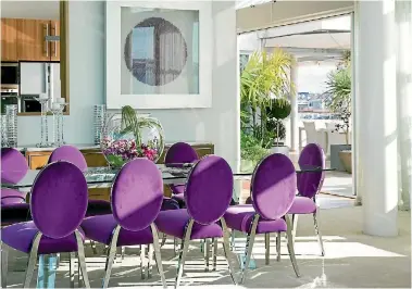  ?? PAUL MCCREDIE ?? Purple dining chairs create a talking point in this formal dining room.