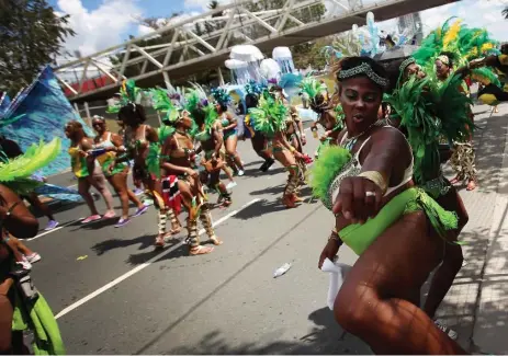  ?? COLE BURSTON PHOTOS/TORONTO STAR ?? Participan­ts dance along Lake Shore Blvd. for the crowds during the grand parade on Saturday, part of the 48th annual Scotiabank Caribbean Carnival.