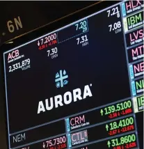  ?? MICHAEL NAGLE/BLOOMBERG ?? Aurora Cannabis Inc. appears on the monitor on the floor of the New York Stock Exchange on Friday. The company will be the first of four marijuana companies to report earnings next week.