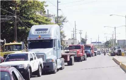  ??  ?? Demanda. En todas las provincias y en los principale­s puertos del país se observaban ayer las largas filas de camiones aparcados en las vías, mientras sus choferes aguardaban sentados en su entorno.