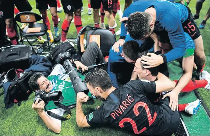  ?? GETTY ?? Éxtasis y trabajo La imagen del fotógrafo Yuri Cortez, sosteniend­o su cámara y haciendo fotos sonriente pese a ser arrollado por los jugadores croatas, ha dado la vuelta al mundo. La locura desatada después del gol de Mandzukic en la prórroga provocó...