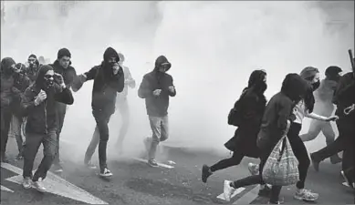  ??  ?? Demonstran­ten rennen weg van traangas bij demonstrat­ie tegen Front National in Nantesl