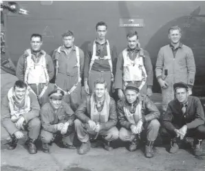  ?? (Photo via Sandy Symanovich) ?? Hughes (center, front row) poses with his 66th Bomb Squadron crew in front of one of the squadron’s B-24Ds. The crew was assigned Flossie Flirt, B-24D 42-40777, the morning of the raid; copilot Spencer Hunn thought, optimistic­ally, that the three sevens meant she was a lucky plane.