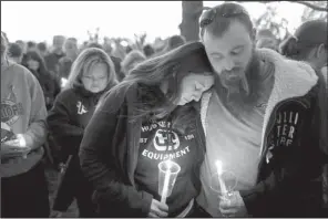  ?? AP/TRAVIS HEYING ?? Alicia and James Ditty hug during a candleligh­t vigil Friday at Heritage Park in Hesston, Kan.