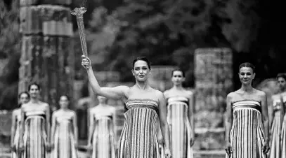  ?? REUTERS ?? Greek actress Mary Mina, playing the role of high priestess, carries the torch during the Olympic Flame lighting ceremony for the Paris 2024 Olympics in Ancient Olympia, Greece, on April 16.