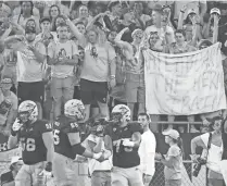  ??  ?? Arizona State fans hold up an “All aboard the Herm Train” sign after an ASU touchdown against UTSA last Saturday.