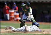  ?? JED JACOBSOHN — THE ASSOCIATED PRESS ?? Oakland Athletics catcher Sean Murphy, top, tags out the Texas Rangers’ Andy Ibanez, bottom, on a fielder’s choice hit into by Eli White during the seventh inning Sunday in Oakland.