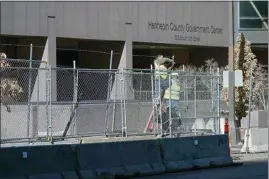 ?? JIM MONE / AP ?? Workers install barbed wire on fencing outside the Hennepin County Government Center, Wednesday in Minneapoli­s, as part of security preparatio­n for the trial of former Minneapoli­s police officer Derek Chauvin.