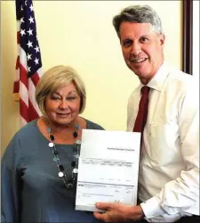  ?? . (Messenger photo/Mike O’Neal) ?? Walker County Commission­er Bebe Heiskell accepting an $84,337 check, part of the $5 million proceeds from liquidatio­n of a statewide workers' compensati­on insurance fund, from ACCG Executive Director Ross King