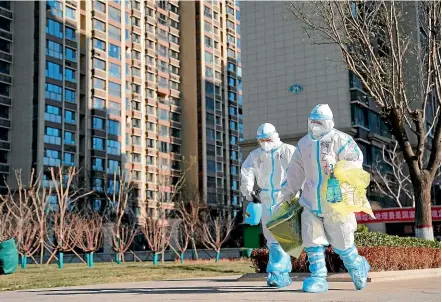  ?? AP ?? Health workers carry a container of coronaviru­s test samples taken from residents at a housing complex in Shijiazhua­ng in northern China’s Hebei province. Millions of people are being tested as part of efforts to control China’s most serious recent outbreak of Covid-19.