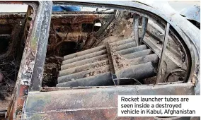  ??  ?? Rocket launcher tubes are seen inside a destroyed vehicle in Kabul, Afghanista­n