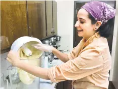  ?? Brian Koonz / For Hearst Connecticu­t Media Group ?? Left, Kathryn Campbell at Crumb Together Bakery rolls a chocolate crinkle cookie ball in powdered sugar before baking while, above, Becca Nassim, an instructor and the bakery’s executive baker, mixes the dough for challah bread. Below, the scent of cinnamon fills the air as Melissa Weaver, a Sacred Heart University senior, removes a tray of snickerdoo­dles from the oven.