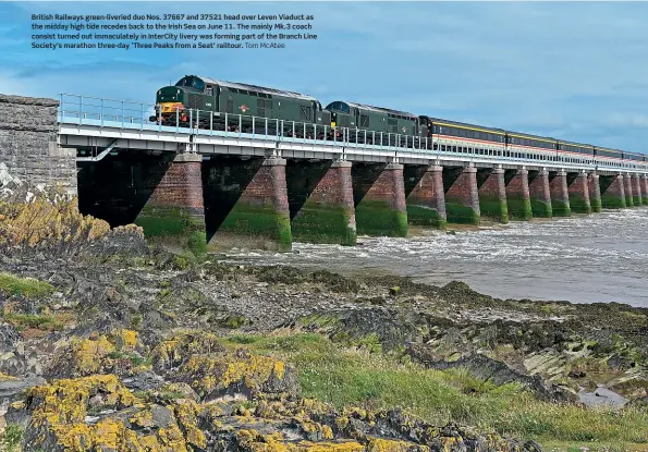  ?? Tom McAtee ?? British Railways green-liveried duo Nos. 37667 and 37521 head over Leven Viaduct as the midday high tide recedes back to the Irish Sea on June 11. The mainly Mk.3 coach consist turned out immaculate­ly in InterCity livery was forming part of the Branch Line Society's marathon three-day ‘Three Peaks from a Seat' railtour.