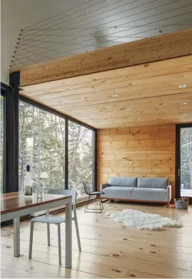  ??  ?? This New Hampshire cabin interior pairs exposed wood with warm and inviting textiles for a picture-perfect and welcoming look.
