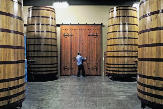  ?? Photos by Jason Henry / Special to The Chronicle ?? John Concannon opens the door in the barrel room at his family’s vineyard in Livermore. The Wine Group bought the winery in 2002, but he runs the day-to-day.