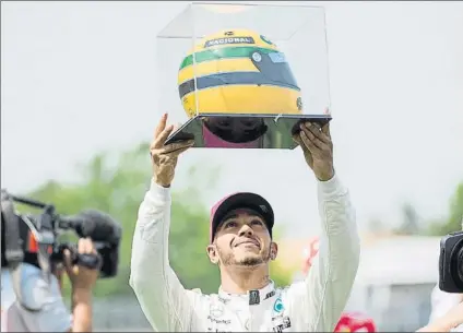  ?? FOTO: AP ?? Lewis Hamilton, emocionado al recibir un casco de Ayrton Senna por parte de la familia del mítico piloto brasileño tras lograr la pole