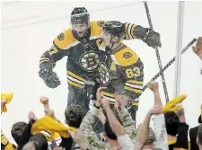  ?? STEVEN SENNE THE ASSOCIATED PRESS ?? Bruins forward Patrice Bergeron, top left, celebrates with Brad Marchand after Marchand scored against the Hurricanes.