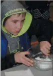  ??  ?? Robert Buell, 13, stirs his homemade slime during a Family Super Saturday Slime Time program at the Oneida Public Library on Saturday, Jan. 12, 2019.