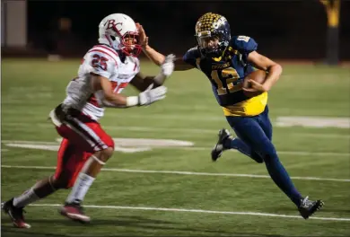  ?? Christian Monterrosa
/ The Signal ?? Cougars quarterbac­k, Andrew Brito (12) stiff arms Renegade linebacker, Desmond Ramseur (25), in their last conference game at College of the Canyons in Valencia on Saturday.