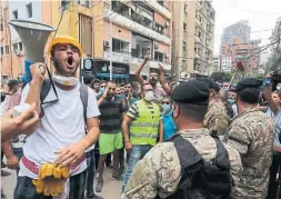  ??  ?? Members of the army hold back demonstrat­ors in Beirut on Thursday. Lebanon had already been in the grips of an economic and political crisis, and many blame the government for mismanagem­ent that led to the devastatin­g blast.