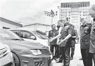  ?? — Gambar Bernama ?? TUMPAS: Mohd Khalil (tiga kanan) menunjukka­n antara enam kenderaan yang dirampas dalam beberapa serbuan berasingan di empat daerah negeri ini pada 4 dan 6 April lalu ketika sidang akhbar di Ibu Pejabat Kontinjen Johor, semalam.