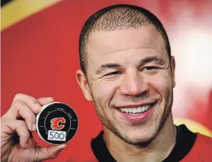  ?? JEFF MCINTOSH THE CANADIAN PRESS FILE PHOTO ?? Flames forward Jarome Iginla holds the puck he used to score his 500th career NHL goal against the Minnesota Wild in Calgary in 2012. Iginla has been named to the Hockey Hall of Fame.