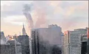  ?? AP ?? Smoke rises from Trump Tower in New York on Monday. Two civilians and a firefighte­r were injured in a fire that started in the heating and air conditioni­ng system of the building.