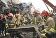  ?? Ebrahim Noroozi / Associated Press ?? Firefighte­rs remove debris from a 17-story building in the heart of Tehran that collapsed and burned.