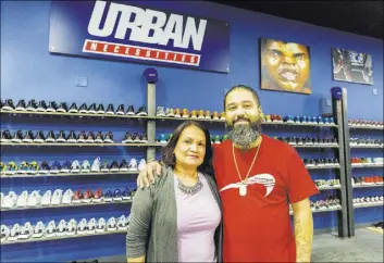  ??  ?? Jaysee Lopez, right, owner of Urban Necessitie­s, says his mom, Maria Vaquez, has worked every day in his store since he moved her to Las Vegas from New Jersey in September.