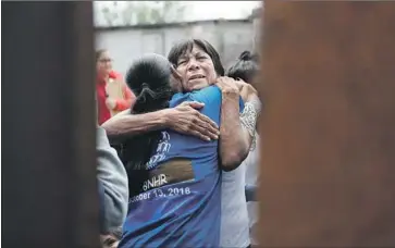  ?? Mario Tama Getty Images ?? GUILLIERMI­NA Pena of Mexico embraces a relative at the “Hugs Not Walls” event in Sunland Park, N.M.