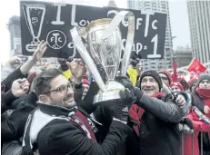  ?? THE CANADIAN PRESS FILES ?? Toronto FC general manager Tim Bezbatchen­ko, left, and president Bill Manning hold the MLS trophy during the team’s championsh­ip parade last month in Toronto.