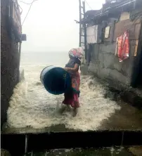  ?? PTI ?? A woman shifts a drum near her house amid heavy showers triggered by Cyclone Ochki in Mumbai on Tuesday. —