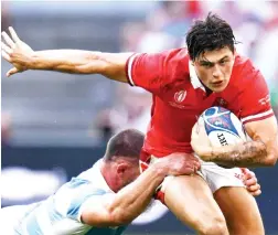  ?? — AFP file photo ?? Wales’ wing Louis Rees-Zammit (right) is tackled during a match.