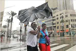  ??  ?? Karon Hill, left, and Celeste Cruz gamely battle wind and rain from Hurricane Barry on Saturday in New Orleans.