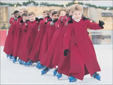  ?? PICTURE: ANDREW MATTHEWS/PA. ?? SLIP AND SLIDE:
Choristers of Winchester Cathedral take to the cathedral’s annual festive ice rink.